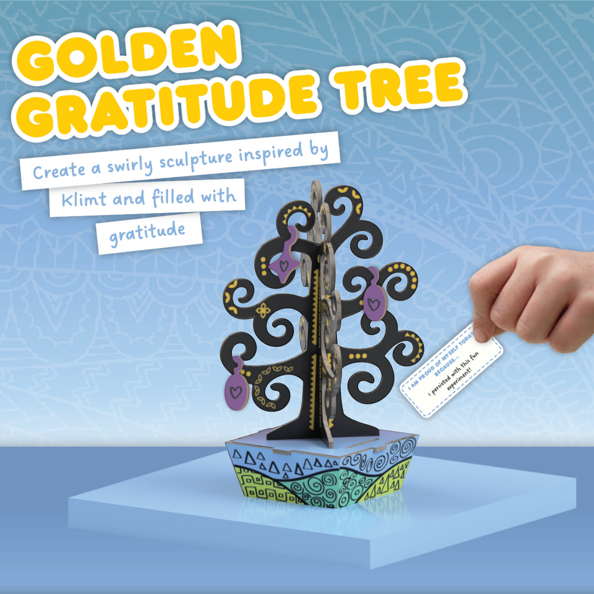 Hand placing a gratitude card into the Golden Gratitude Tree sculpture inspired by Gustav Klimt